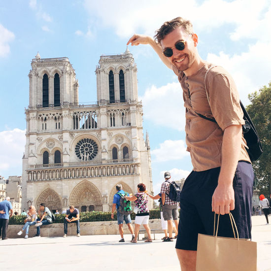 Portrait of man pointing at notre dame