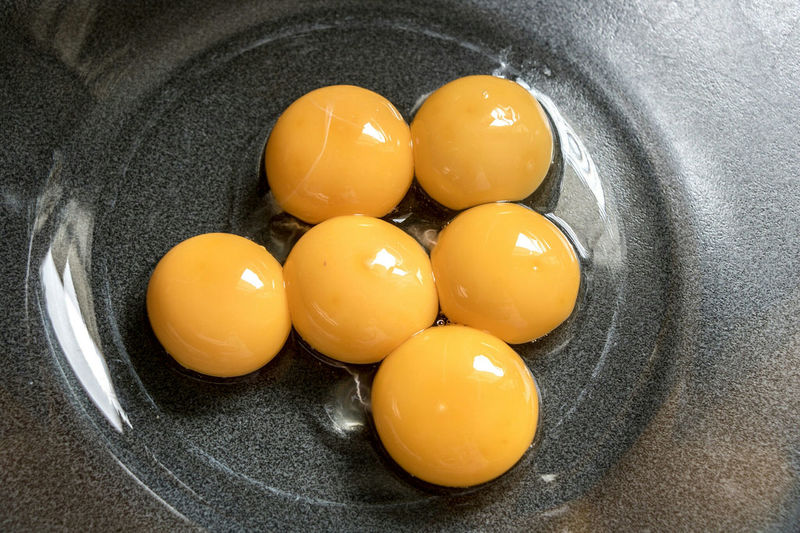 High angle view of yellow eggs in container