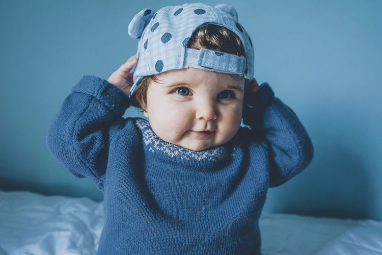 Portrait of cute baby girl wearing cap at home