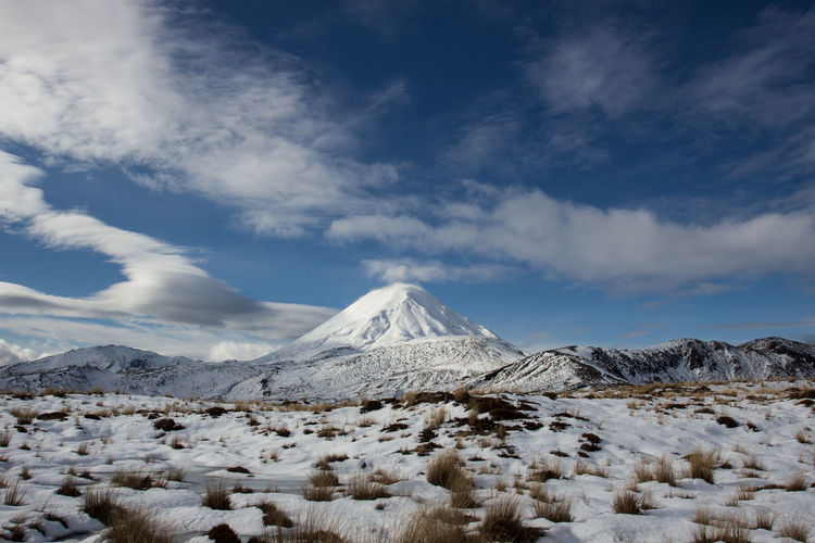 Lenticular clouds beside the snow covered mt ngauruhoe in the tongariro national park