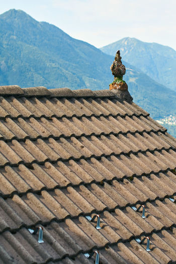 High angle view of statue on roof against sky