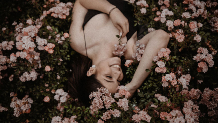 High angle view of woman lying down on flowering plants