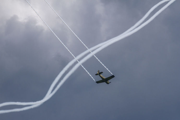 Low angle view of airplane flying against sky