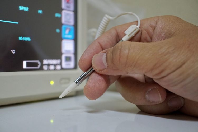 Cropped image of hand writing with digitalized pen by device screen at hospital