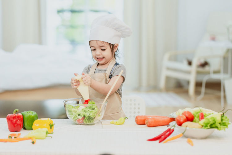 Midsection of woman with vegetables on table