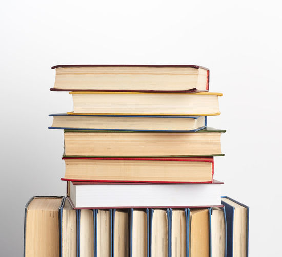 Stack of books on table against white background