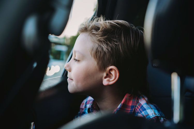 Handsome caucasian boy travelling by car sitting in child seat.recreation concept