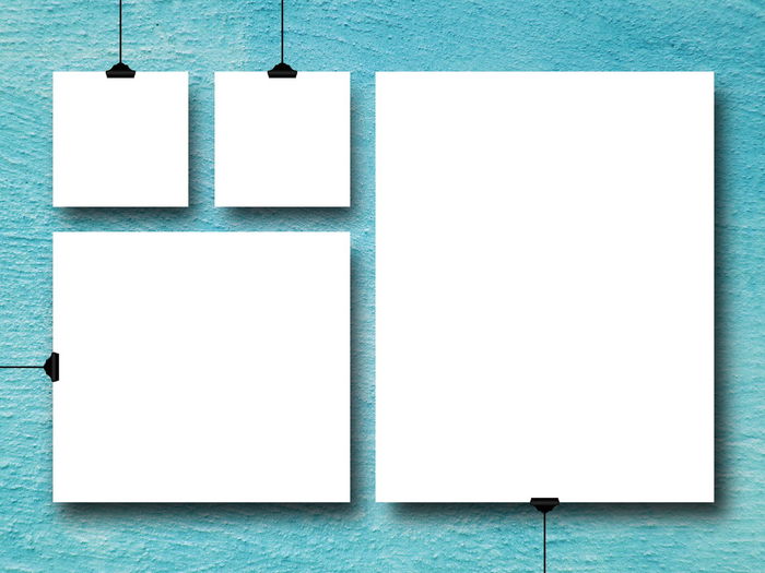 Close-up of blank white papers by turquoise wall