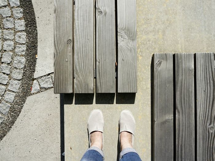 Low section of woman standing by planks