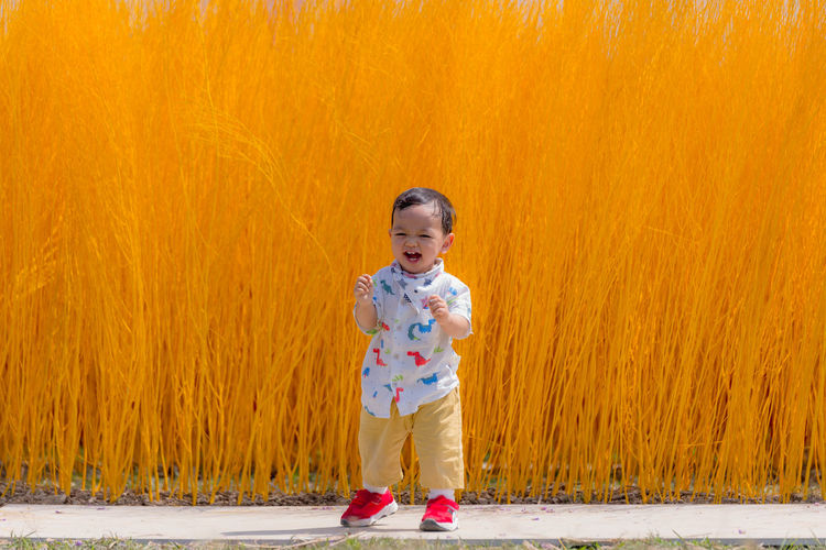 Asian children laughing happily with yellow trees in the background. weekend trip