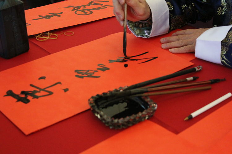 Close-up of human hand writing chinese characters