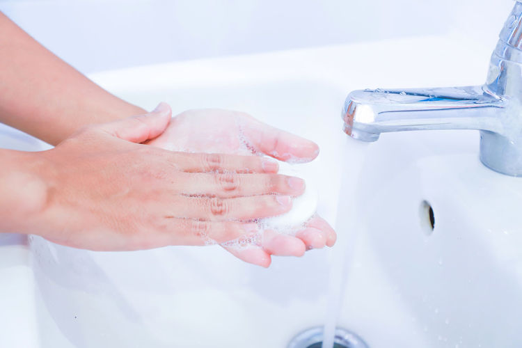 Close-up of hand holding water in bathroom