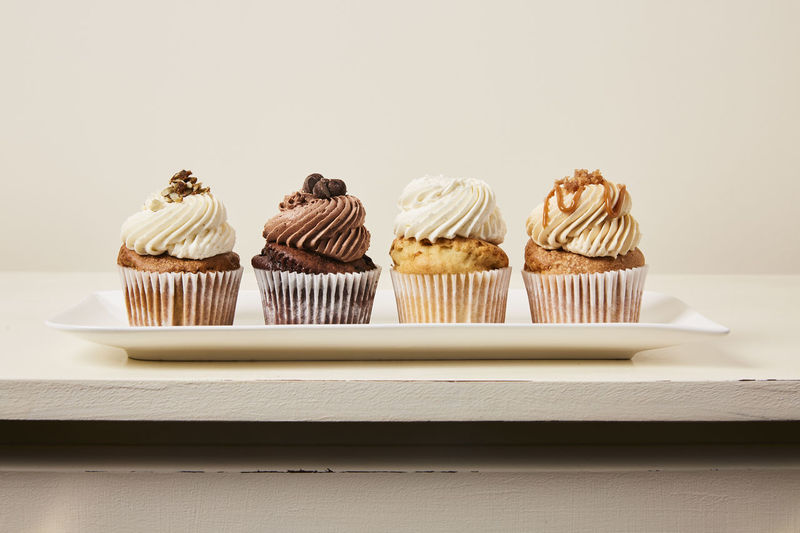 Panoramic shot of cupcakes on table against white background