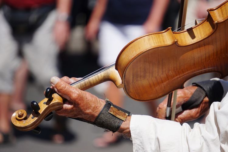 Close-up of man playing violin in city