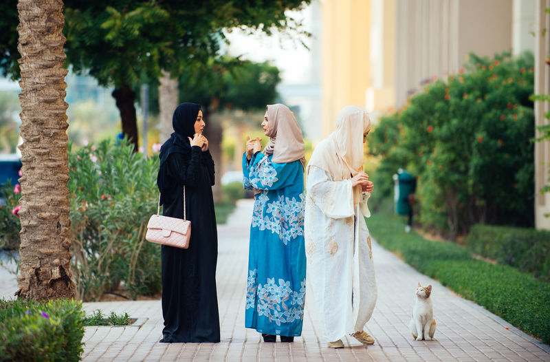 Full length of women wearing hijab standing on footpath