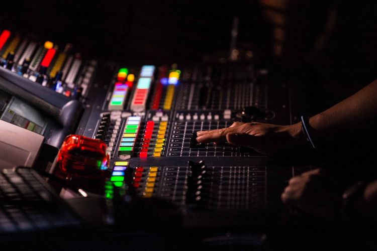 High angle view of cropped dj using sound mixer in nightclub