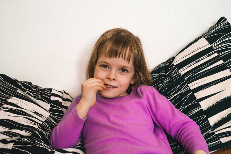 Young woman sitting on sofa at home