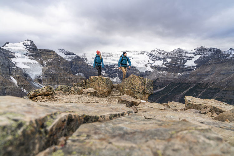 Couple summiting mount fairview in front of victoria glacier
