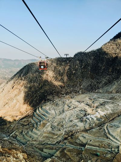 View of overhead cable car against mountain