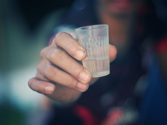 Cropped image of person holding drinking glass