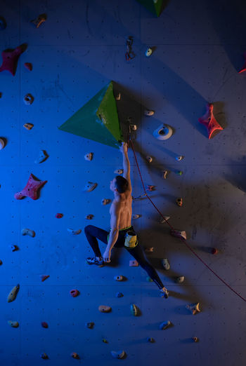 Male boulderer planning climbing route on wall