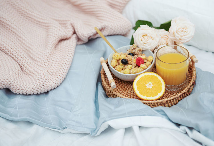 Romantic breakfast with orange juice and rose flowers.