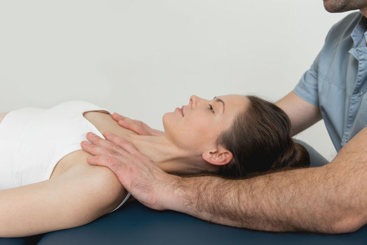 Massage therapist massaging woman at spa