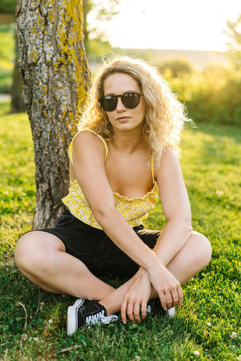 Portrait of young woman sitting on sunglasses