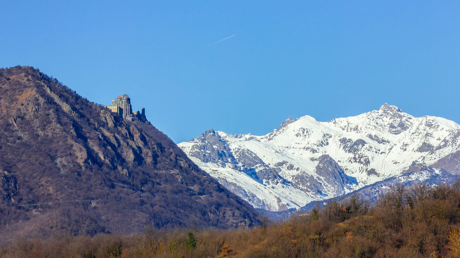 Scenic view of snowcapped mountains against clear blue sky