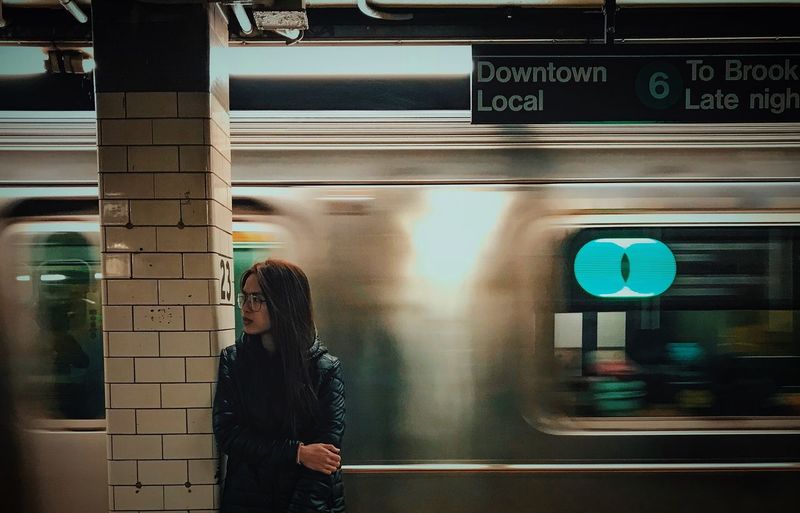 Young woman standing at railroad station