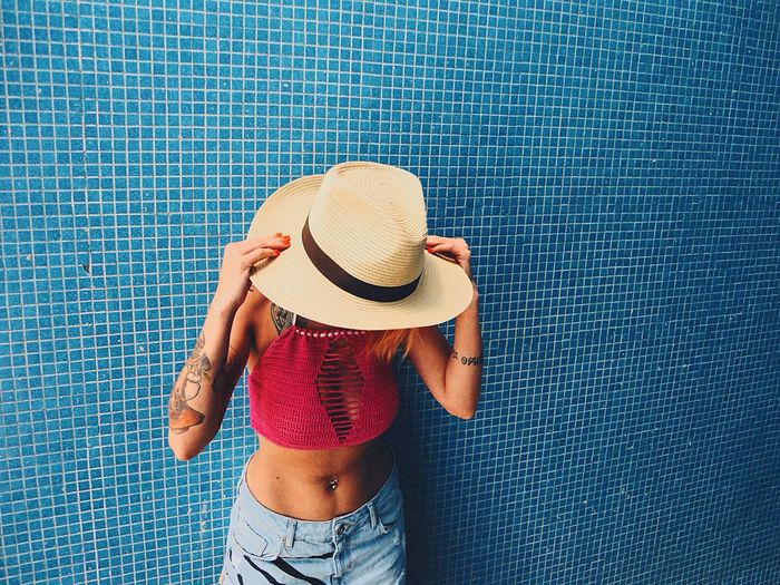 Woman standing against tiled wall
