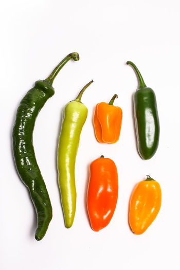High angle view of chili peppers on white background