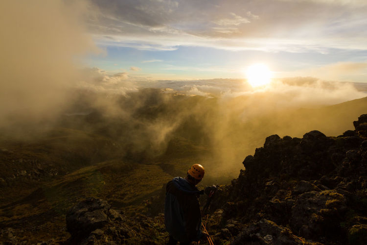 Man standing on mountain during sunset