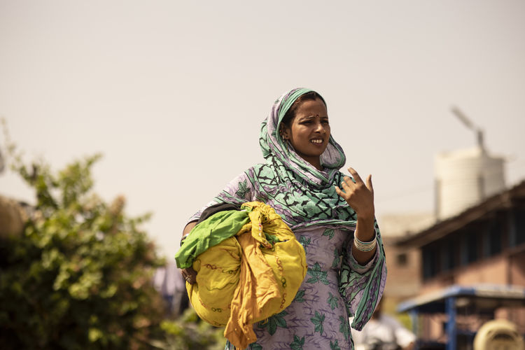 Adult woman carrying a bundle of clothes