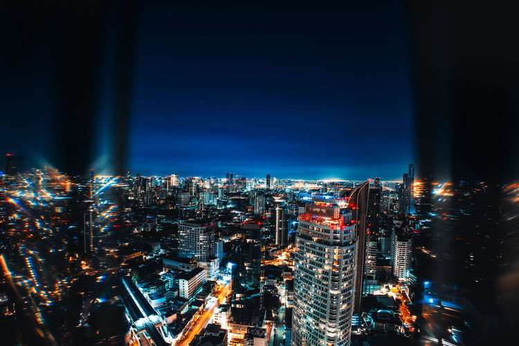 High angle view of illuminated cityscape against sky at night