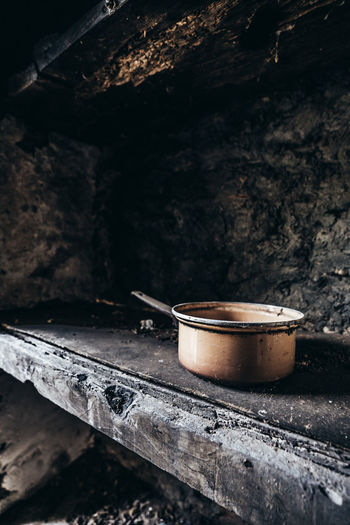 Abandoned lonesome copper pot left behind on an old wooden shelf in a lost place on corsica island.