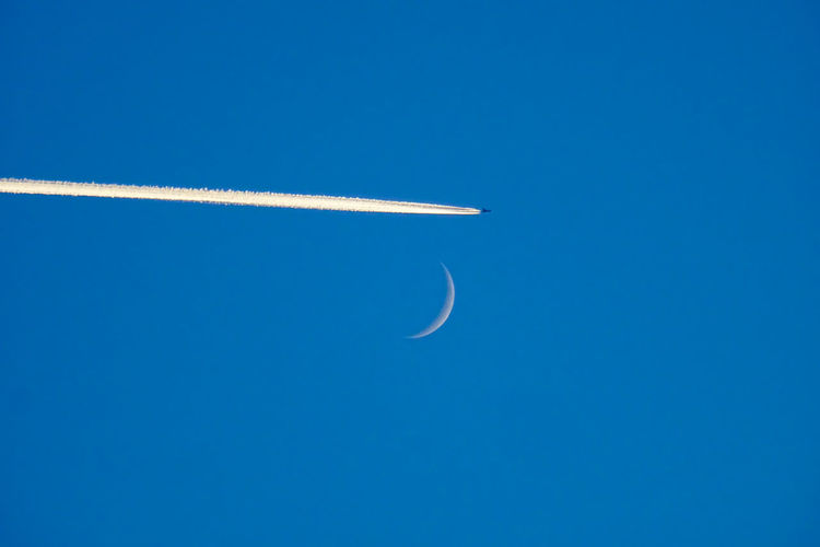 Low angle view of vapor trail against blue sky