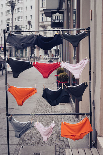 Red flags hanging on street amidst buildings in city