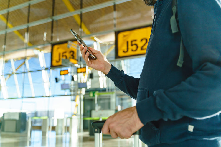 Midsection of man using mobile phone
