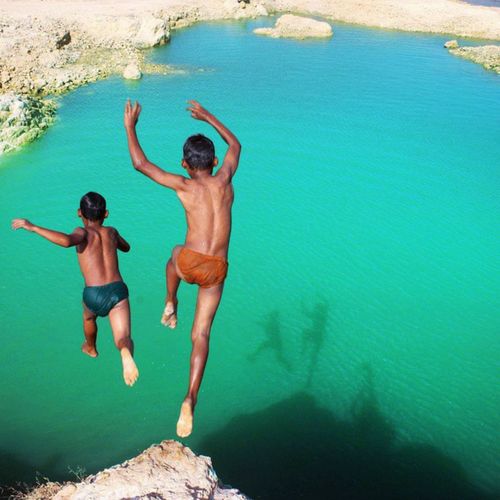 High angle view of men jumping in water