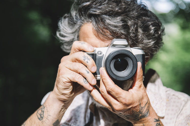 Portrait of a man taking a photo of the viewer with a vintage camera person