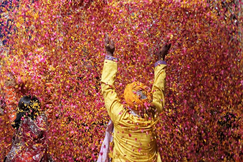 A native rural citizen in his traditional attire throwing flowers to celebrate and fill happiness.