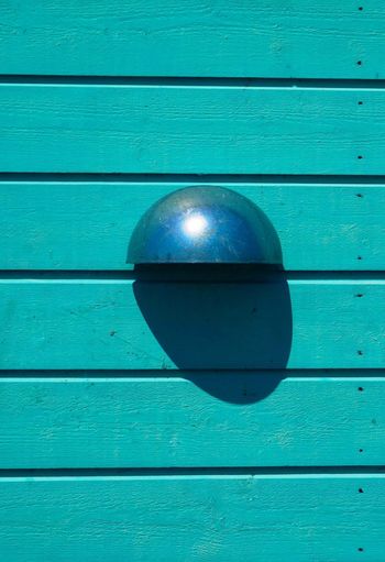 Close-up of metallic door on blue wall