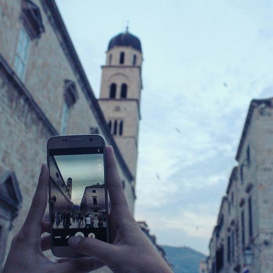 Man photographing building in city