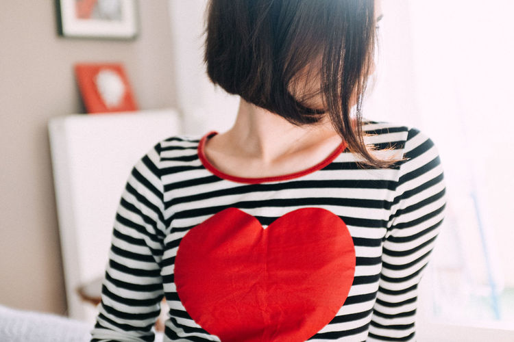Woman with heart shape on t-shirt at home