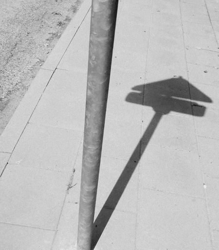 High angle view of shadow on footpath by street