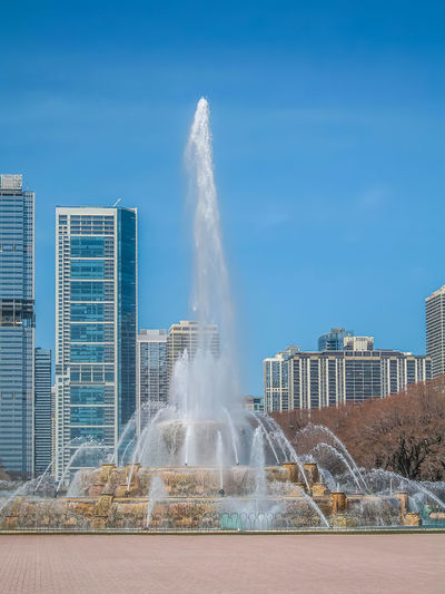 Fountain in city against sky