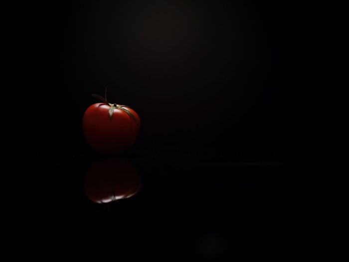 Close-up of tomatoes over black background