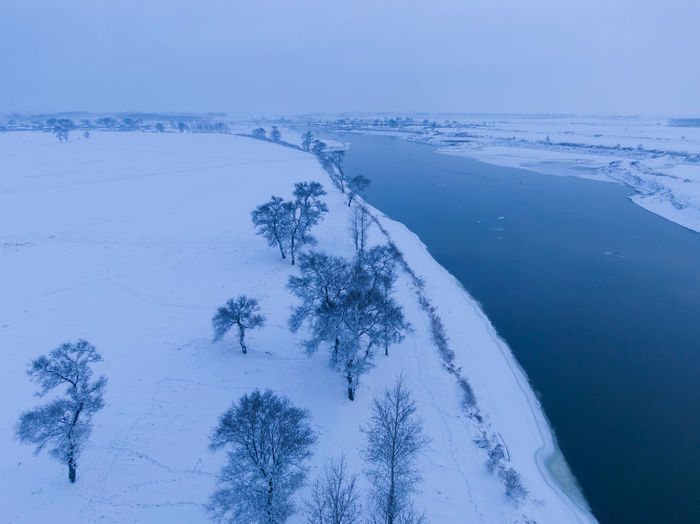 Scenic view of snow covered land against sky