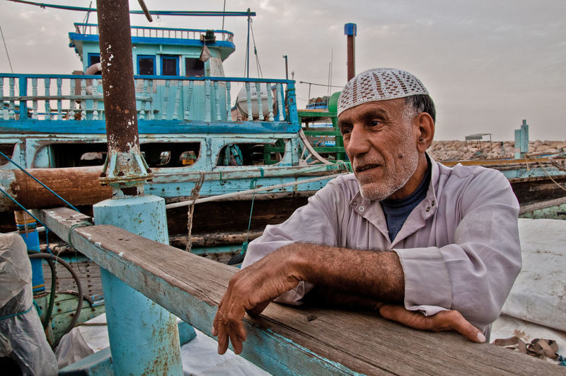 Senior fisherman standing at harbor